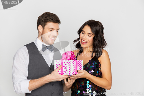 Image of happy couple with gift box at birthday party