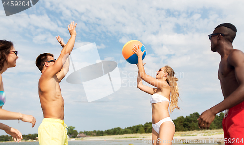 Image of friends playing with beach ball in summer
