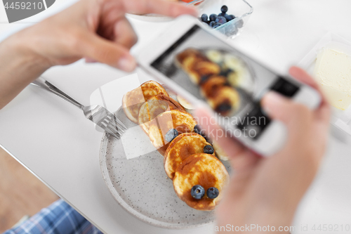 Image of hands with smartphones photographing food