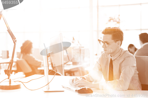 Image of Young businessman using computer at work