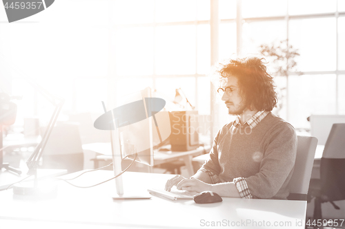 Image of Young businessman using computer at work