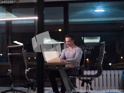 Image of man working on laptop in dark office