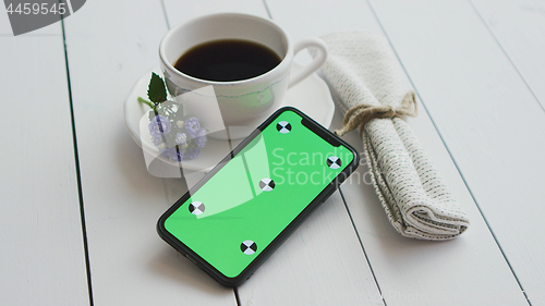 Image of Black coffee with smart phone, on white rustic wooden table