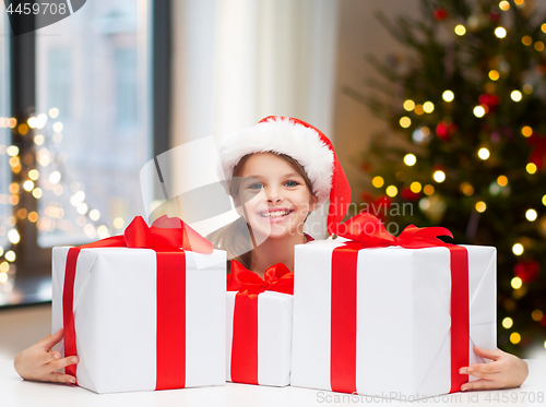 Image of happy girl with christmas gifts at home