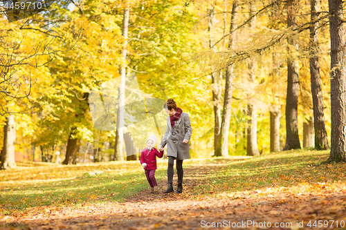 Image of happy mother and little daughter at autumn park