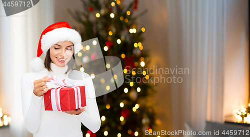 Image of smiling woman in santa hat with christmas gift