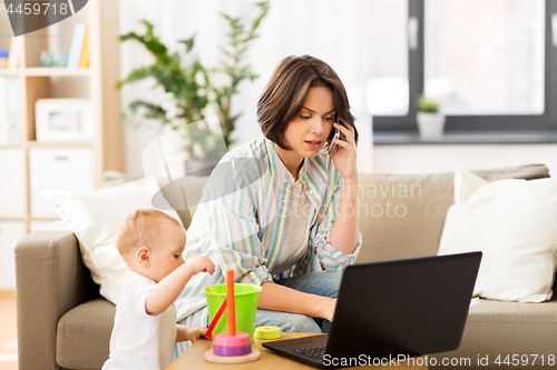 Image of working mother with baby calling on smartphone