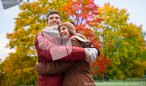 Image of happy teenage couple hugging in autumn park