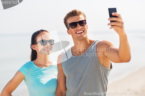 Image of couple taking selfie by smartphone on beach