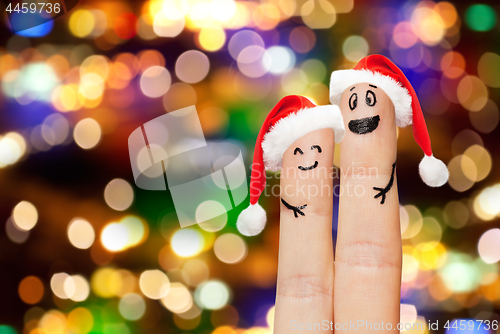 Image of finger couple in santa hats over lights