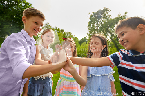 Image of group of happy kids making high five outdoors