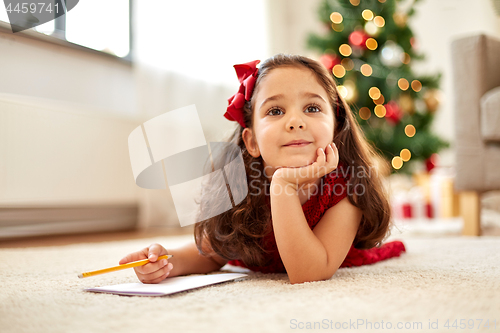 Image of little girl making christmas wish list at home