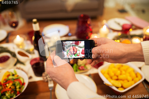 Image of hands photographing food at christmas dinner