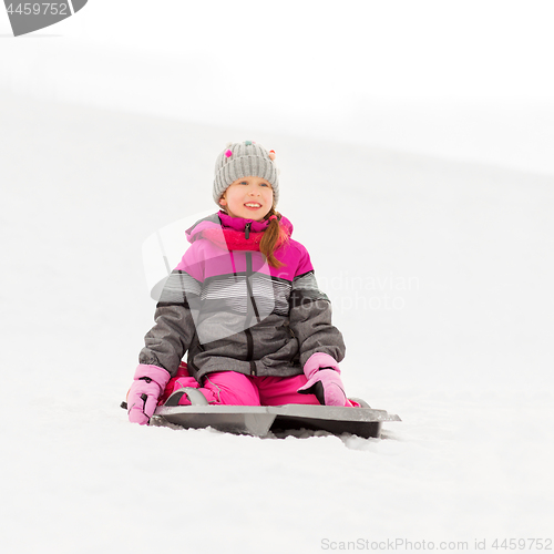 Image of happy little girl on sled outdoors in winter