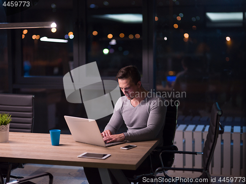 Image of man working on laptop in dark office