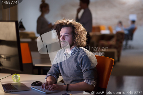 Image of man working on computer in dark office