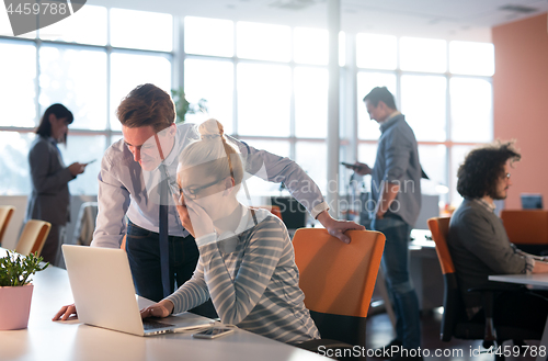 Image of Two Business People Working With laptop in office