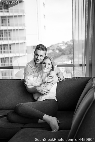 Image of young handsome couple hugging on the sofa