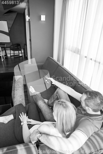 Image of Young couple on the sofa watching television