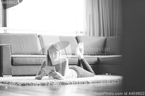 Image of young women using tablet computer on the floor