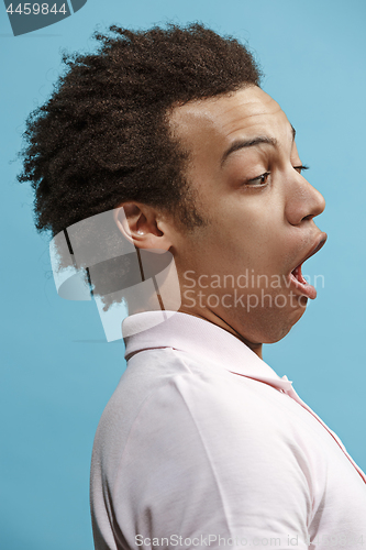 Image of The young attractive man looking suprised isolated on blue