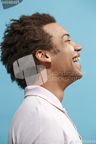 Image of The happy business man standing and smiling against blue background.