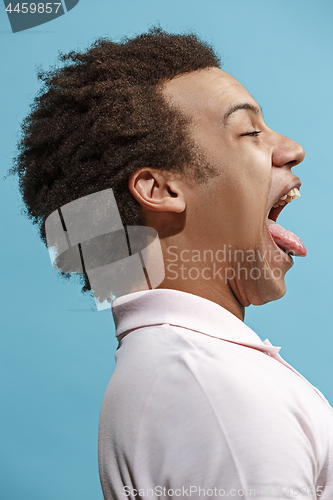 Image of The happy business man standing and smiling against blue background.