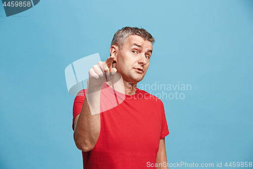 Image of The serious business man point you and want you, half length closeup portrait on blue background.