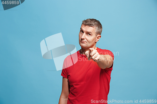 Image of The serious business man point you and want you, half length closeup portrait on blue background.