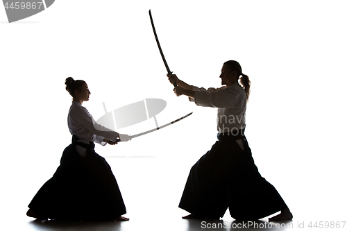 Image of Man and woman fighting and training aikido on white studio background