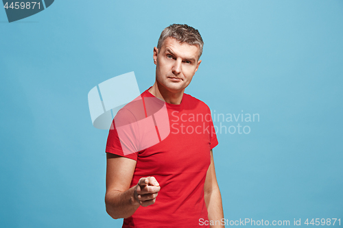 Image of The serious business man point you and want you, half length closeup portrait on blue background.