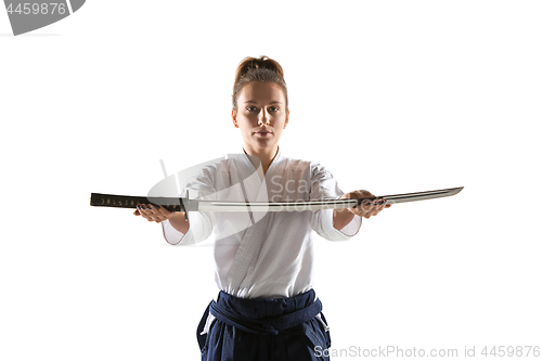 Image of Aikido master practices defense posture. Healthy lifestyle and sports concept. Woman in white kimono on white background.