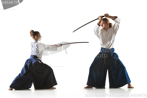 Image of Man and woman fighting and training aikido on white studio background