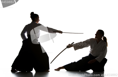 Image of Man and woman fighting and training aikido on white studio background