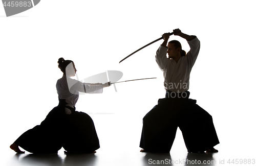 Image of Man and woman fighting and training aikido on white studio background