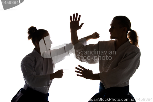 Image of Man and woman fighting at Aikido training in martial arts school