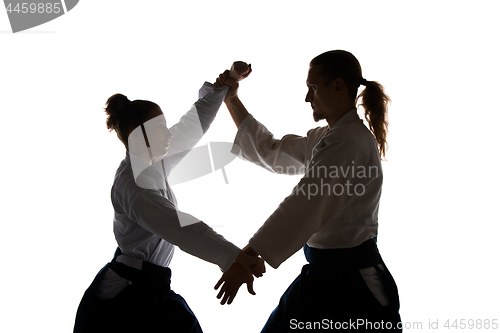 Image of Man and woman fighting at Aikido training in martial arts school