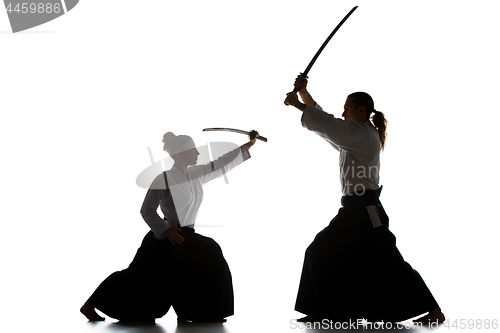 Image of Man and woman fighting and training aikido on white studio background