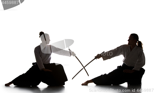 Image of Man and woman fighting and training aikido on white studio background