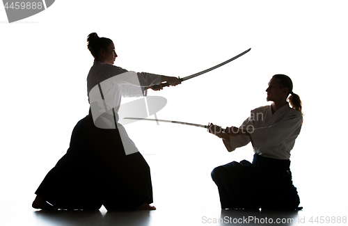 Image of Man and woman fighting and training aikido on white studio background