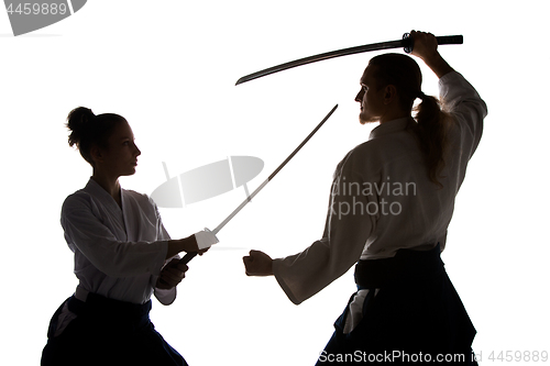 Image of Man and woman fighting and training aikido on white studio background