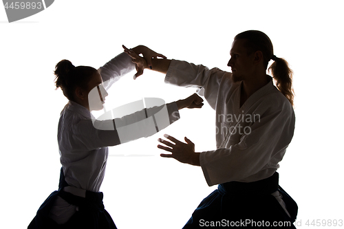 Image of Man and woman fighting at Aikido training in martial arts school