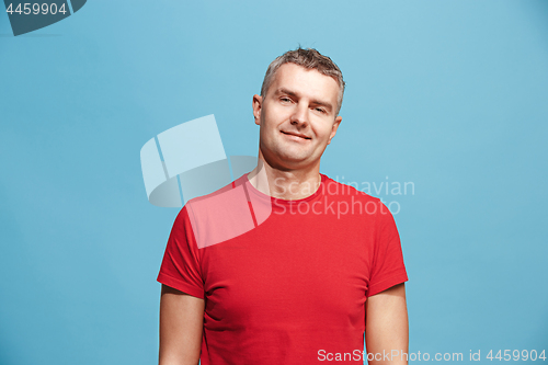 Image of The happy business man standing and smiling against blue background.