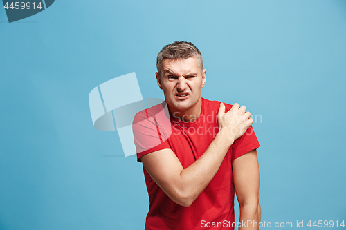 Image of Young man overwhelmed with a pain in the shoulder