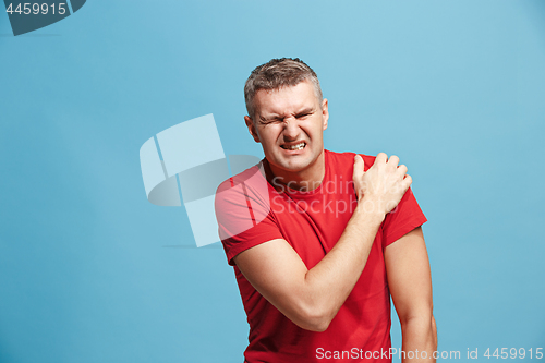 Image of Young man overwhelmed with a pain in the shoulder