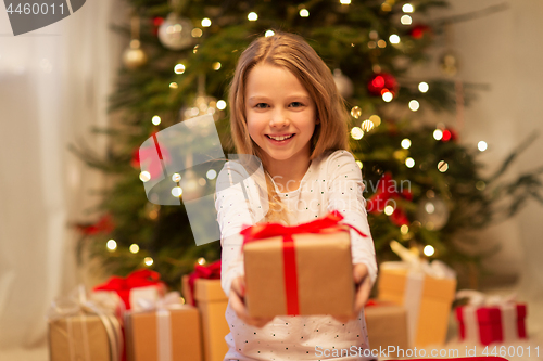 Image of smiling girl with christmas gift at home