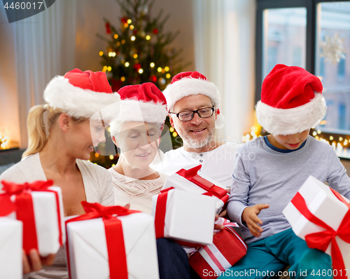 Image of happy family with christmas gifts at home