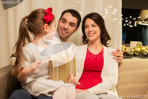 Image of happy family with christmas present at home