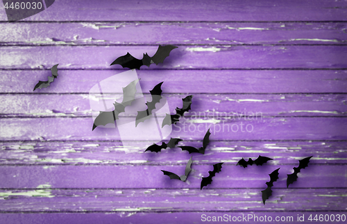 Image of black bats over ultra violet shabby boards