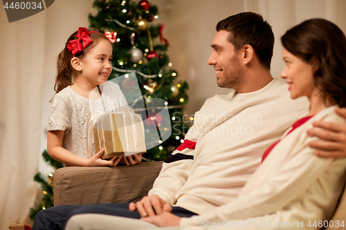 Image of happy family with christmas present at home